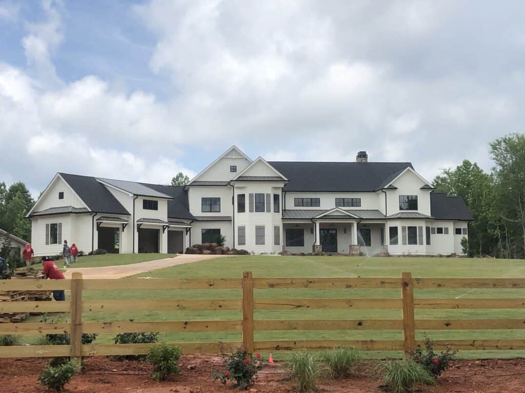 Newly built luxury home with white exterior and black roof by JP Nichols Construction.