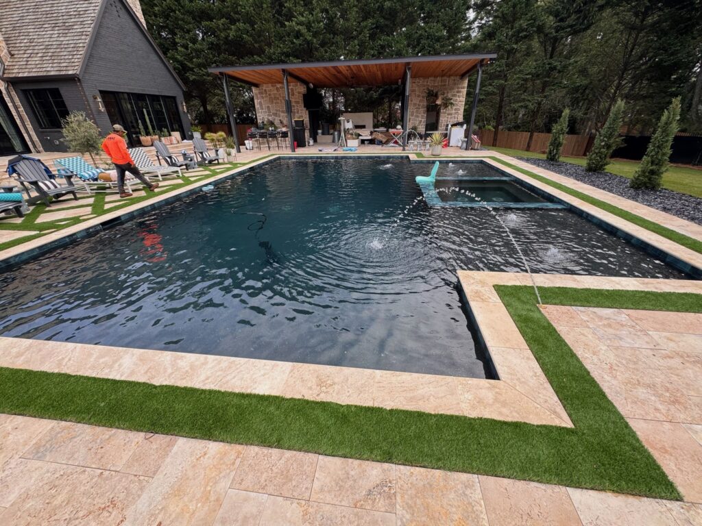 Beautiful in-ground swimming pool with landscaping and outdoor living area.