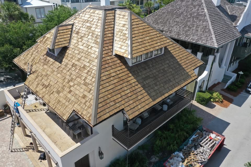 Aerial view of a house roof with cedar shake and dormer windows.